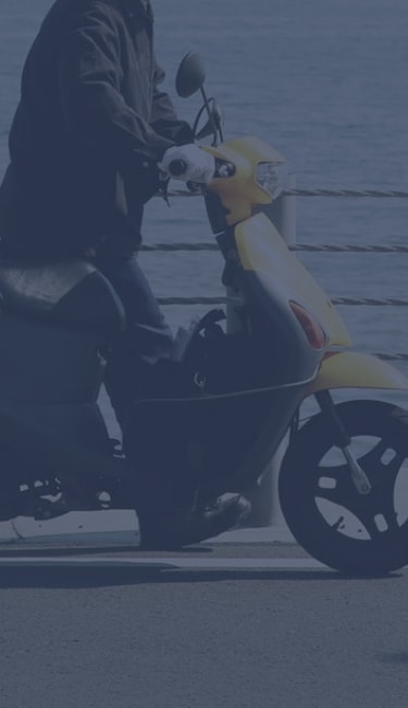man riding yellow scooter on bridge